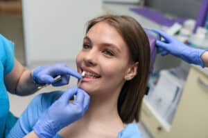 Woman being fitted for dental veneers during cosmetic dentistry consultation.