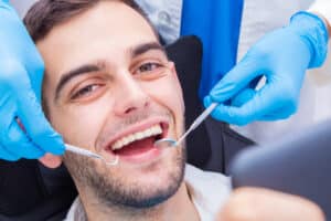 Man smiling and receiving care for tooth damage